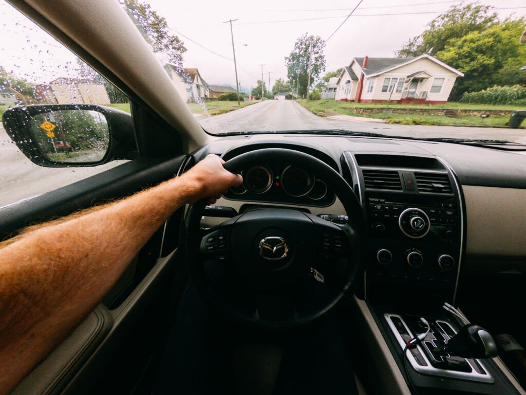 a hand on the steering wheel of an automatic car